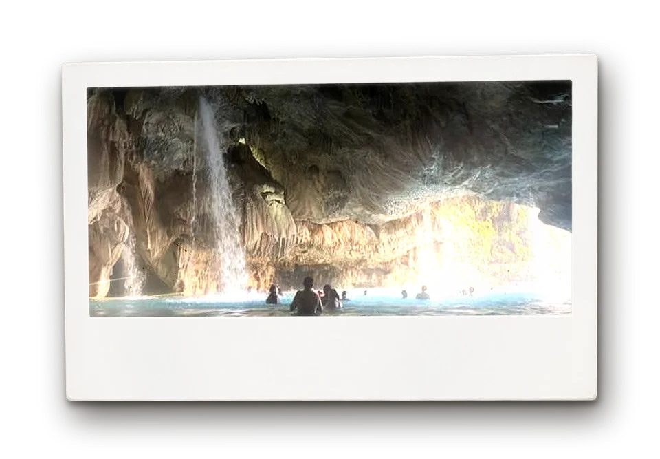 Swimmers in a cave pool beneath a waterfall at Grutas de Tolantongo