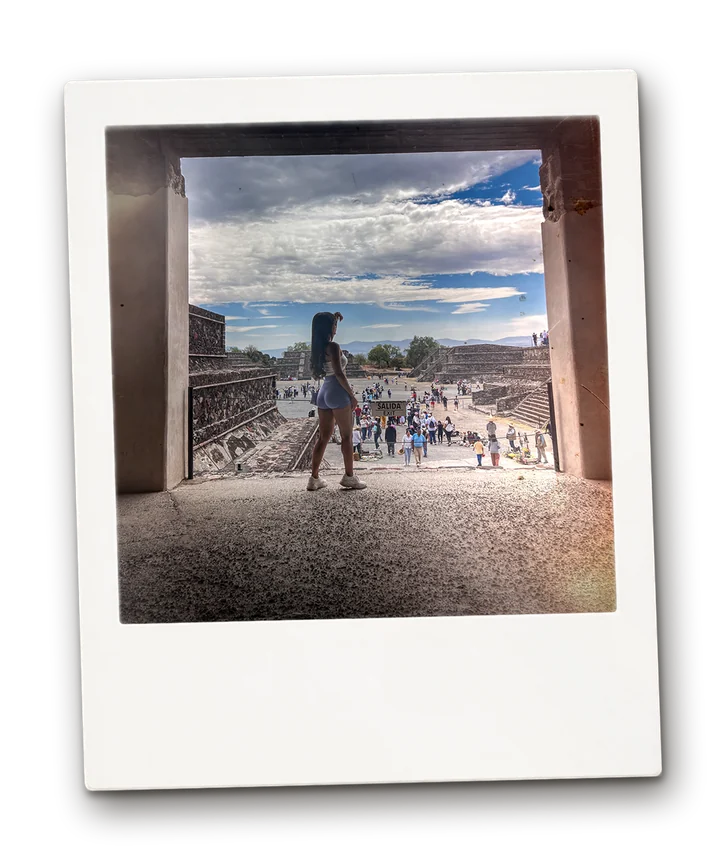 Visitor standing in a stone doorway looking out over the plaza at Teotihuacán